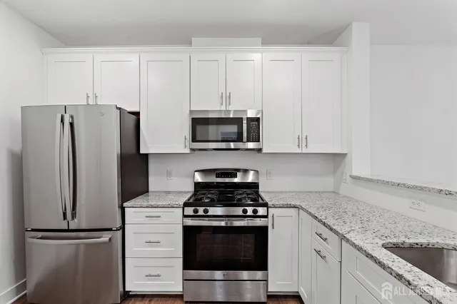 a view of a kitchen with a sink wooden floor and a refrigerator