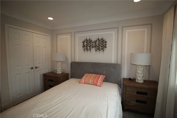 a bedroom with a bed and a painting on the wall