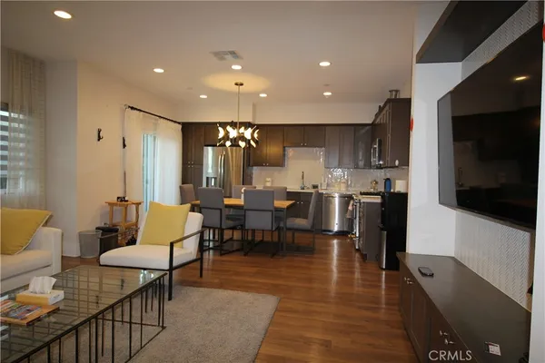 a living room with lots of furniture and kitchen view