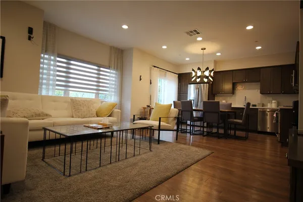 a living room with lots of furniture and kitchen view