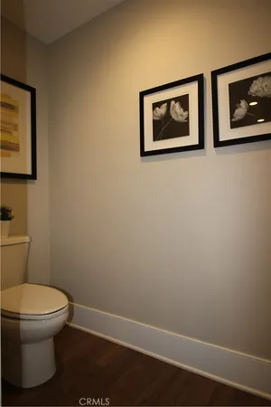 a white toilet sitting next to a white wall