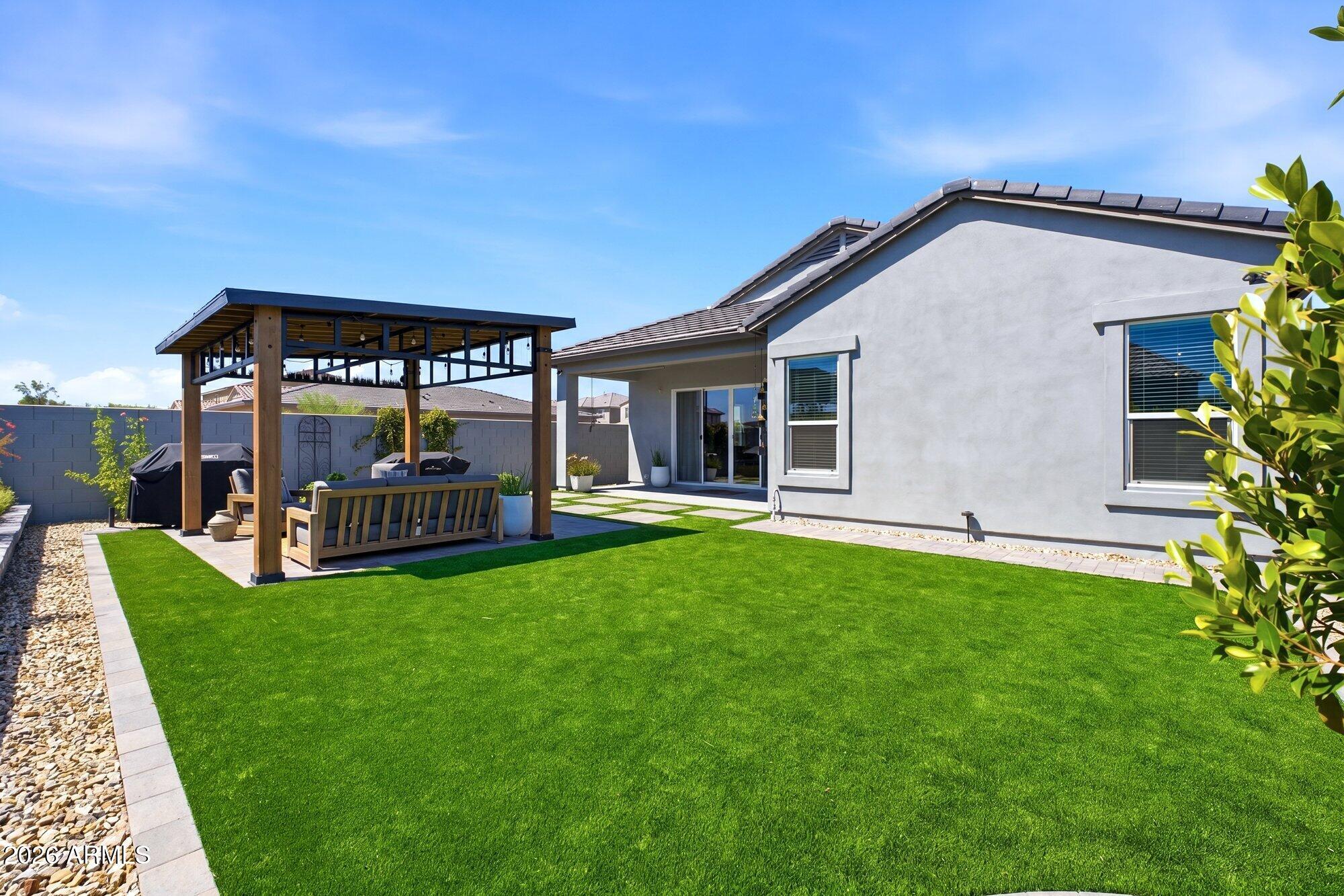 5963 East Lone Cactus Road Phoenix, AZ 85054 - Photo 19 of 22 a view of a house with a yard and sitting area