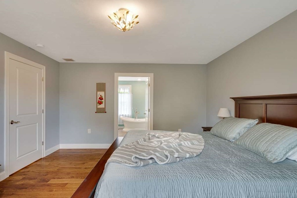 3 Quail Ridge Road Merrimac, MA 01860 - Photo 23 of 36 a bedroom with a bed and a chandelier