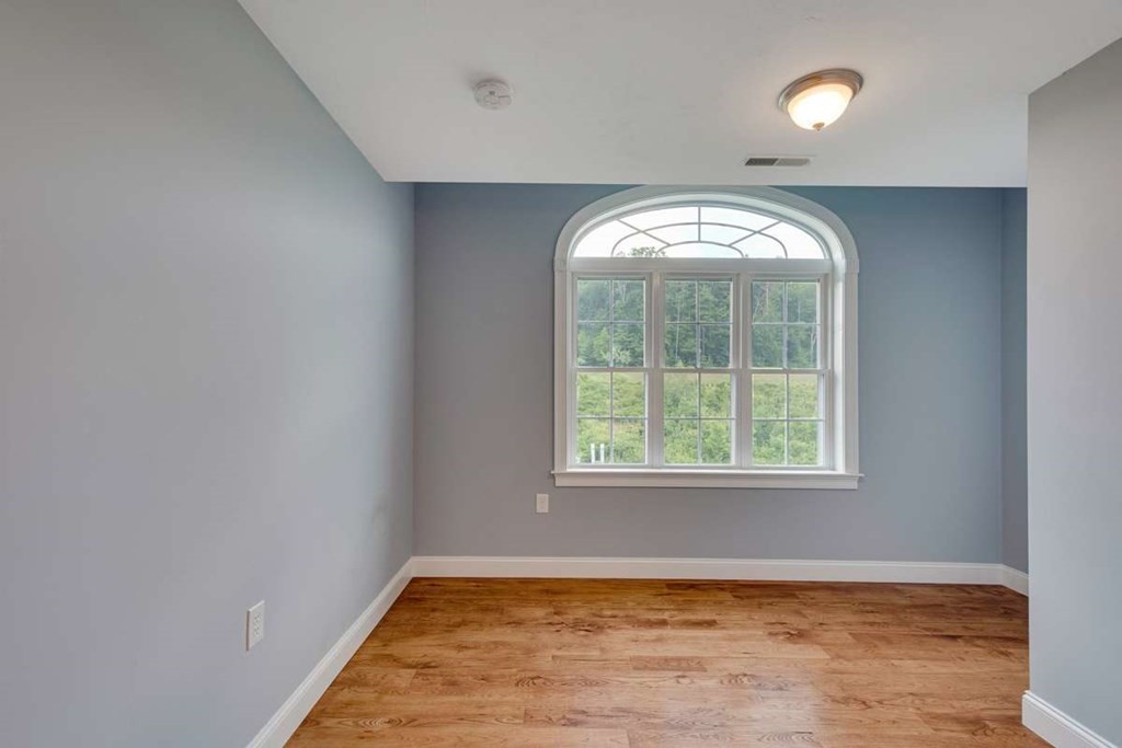 3 Quail Ridge Road Merrimac, MA 01860 - Photo 36 of 36 an empty room with wooden floor mirror and windows