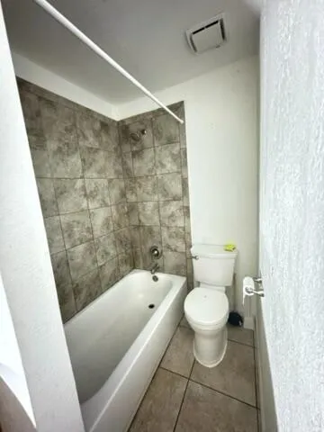 a bathroom with a granite countertop sink toilet and mirror