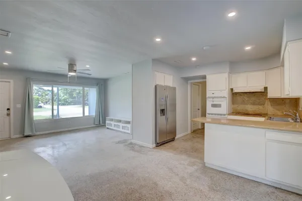 a large kitchen with stainless steel appliances granite countertop a refrigerator and a sink
