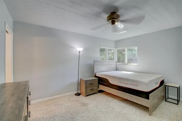 a bedroom with a bed a chandelier and a window