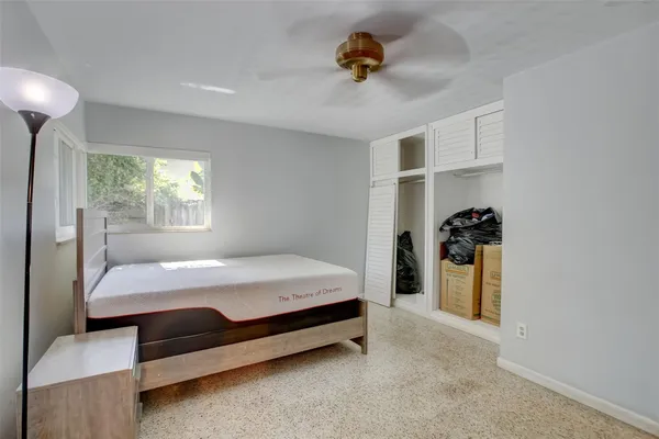 a bed room with a bed and a ceiling fan
