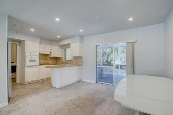 a large white kitchen with white cabinets and stainless steel appliances
