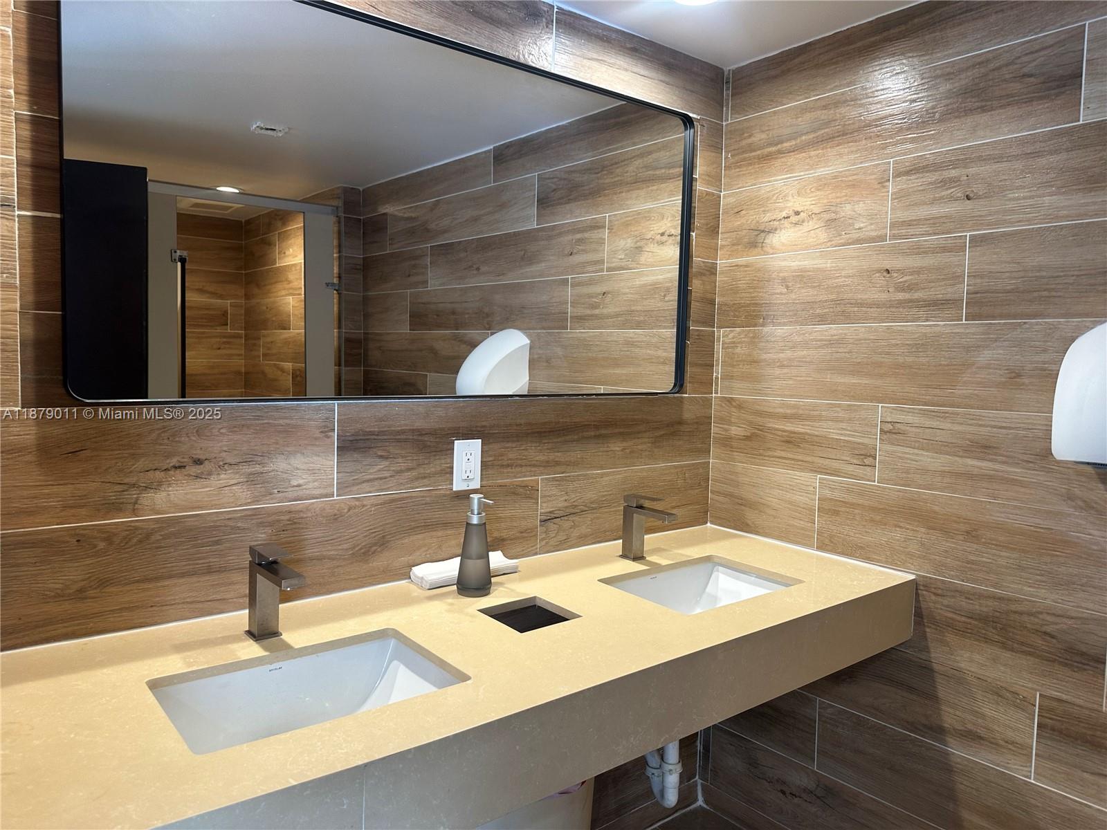 5415 Collins Avenue, Unit 302A Miami Beach, FL 33140 - Photo 18 of 20 a bathroom with a sink and a mirror