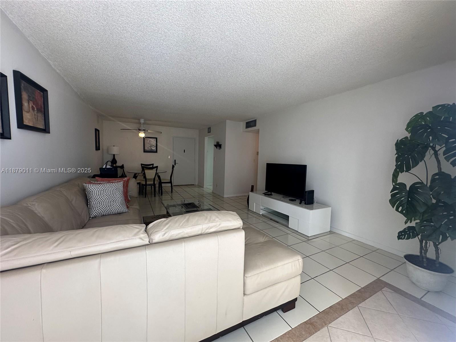 5415 Collins Avenue, Unit 302A Miami Beach, FL 33140 - Photo 4 of 20 a living room with furniture and a flat screen tv