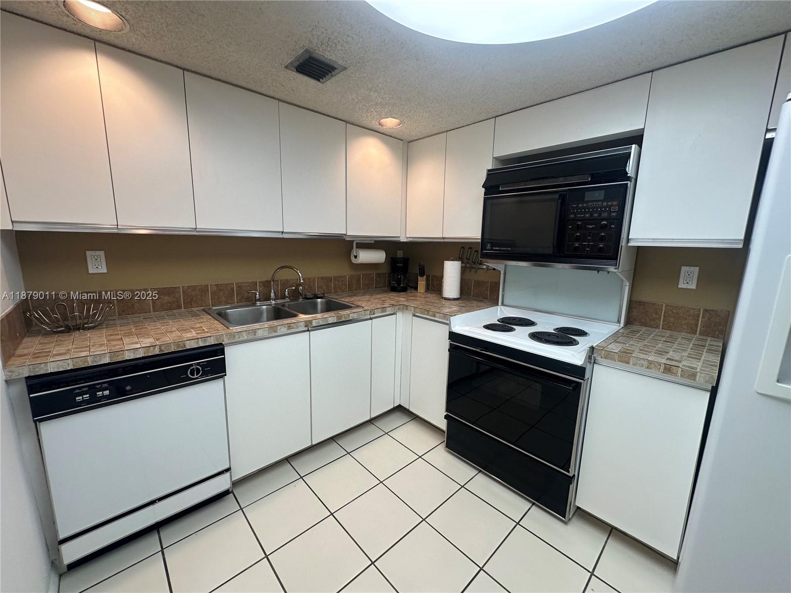 5415 Collins Avenue, Unit 302A Miami Beach, FL 33140 - Photo 6 of 20 a kitchen with granite countertop cabinets stainless steel appliances and a sink