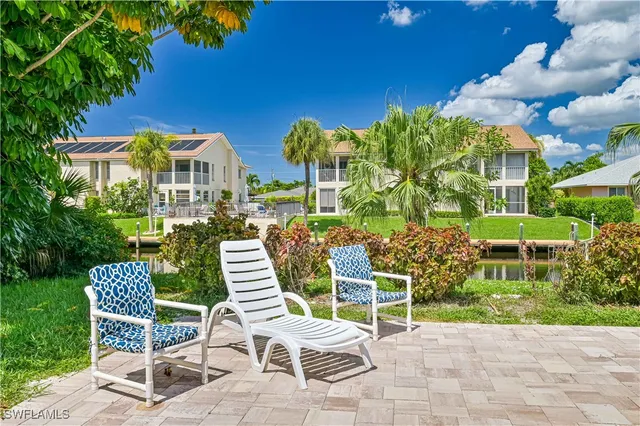 a view of a chairs and tables in the back yard of the house