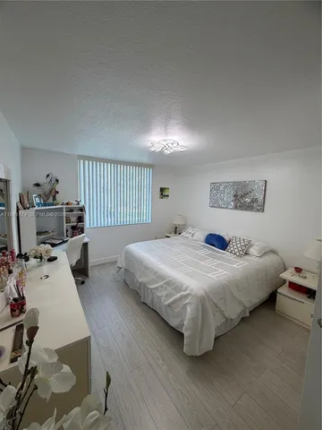 a bedroom with a bed and a view of kitchen