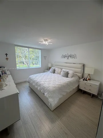 a spacious bedroom with a bed and ceiling fan