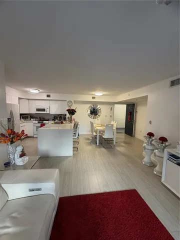 a living room with furniture and kitchen view