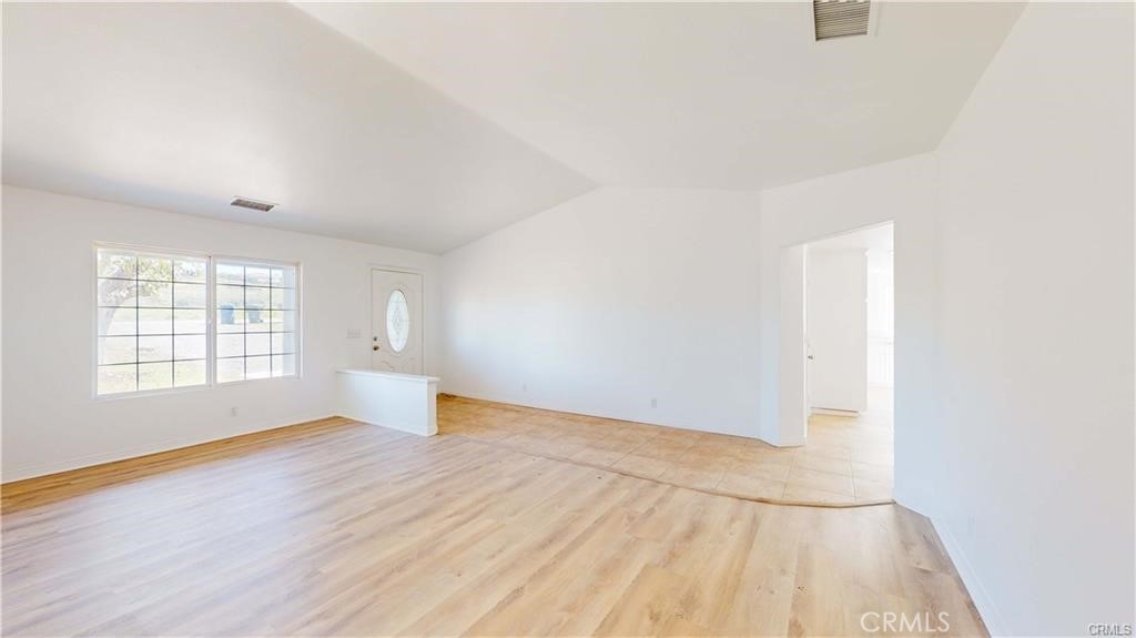 16201 Alta Cresta Avenue Riverside, CA 92508 - Photo 16 of 51 an empty room with wooden floor and windows