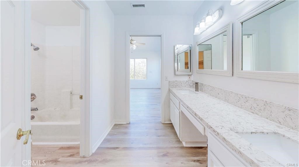 16201 Alta Cresta Avenue Riverside, CA 92508 - Photo 22 of 51 a spacious bathroom with a granite countertop bathtub a sink and a mirror