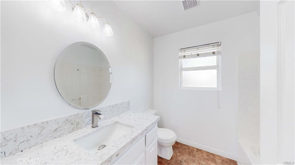 16201 Alta Cresta Avenue Riverside, CA 92508 - Photo 29 of 51 a bathroom with a sink a toilet and a mirror