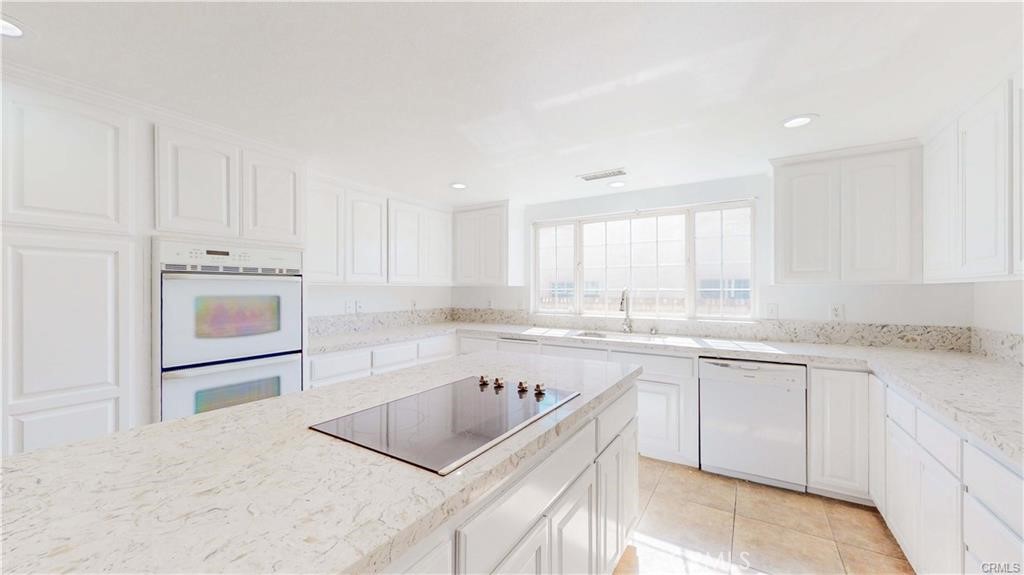 16201 Alta Cresta Avenue Riverside, CA 92508 - Photo 4 of 51 a kitchen with granite countertop white cabinets and white appliances