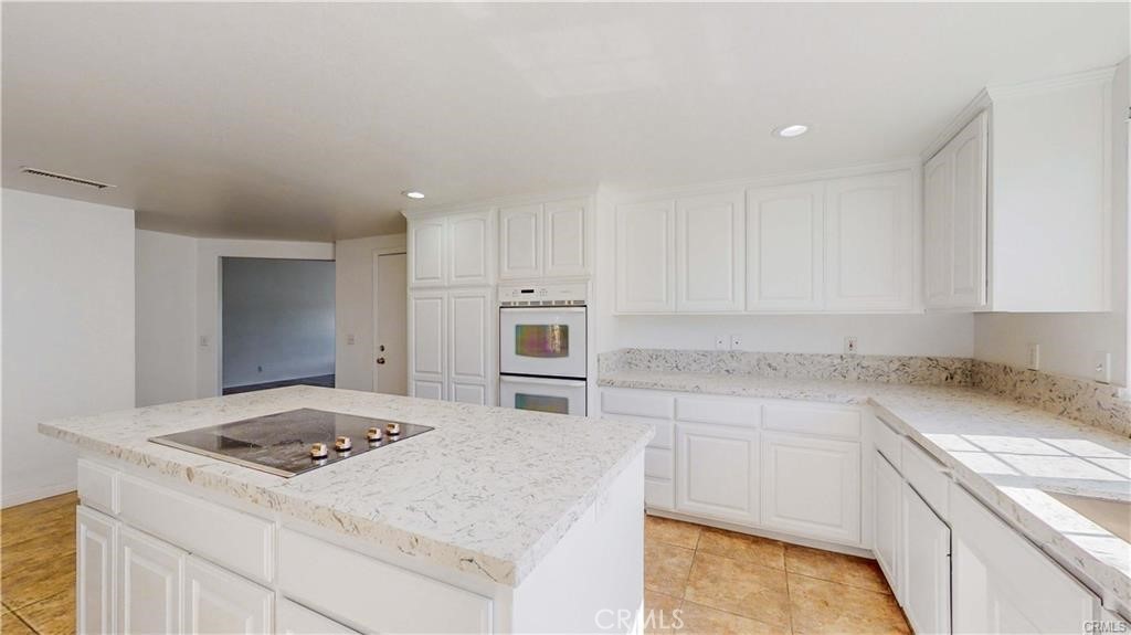 16201 Alta Cresta Avenue Riverside, CA 92508 - Photo 5 of 51 a kitchen with granite countertop a stove sink and refrigerator