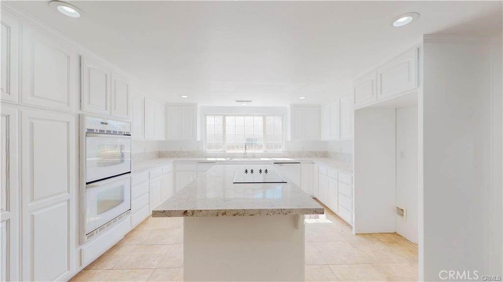 16201 Alta Cresta Avenue Riverside, CA 92508 - Photo 8 of 51 a kitchen with white cabinets and refrigerator