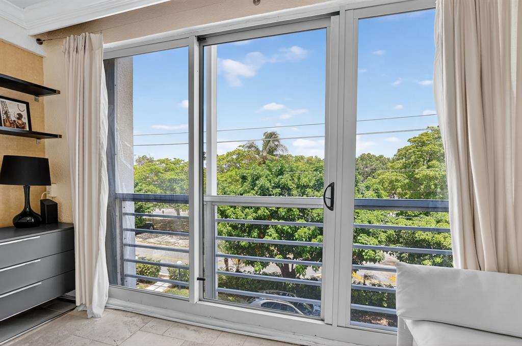 850 Northeast Spanish River Boulevard, Unit 33 Boca Raton, FL 33431 - Photo 20 of 37 a view of a room that has a large window and a bed