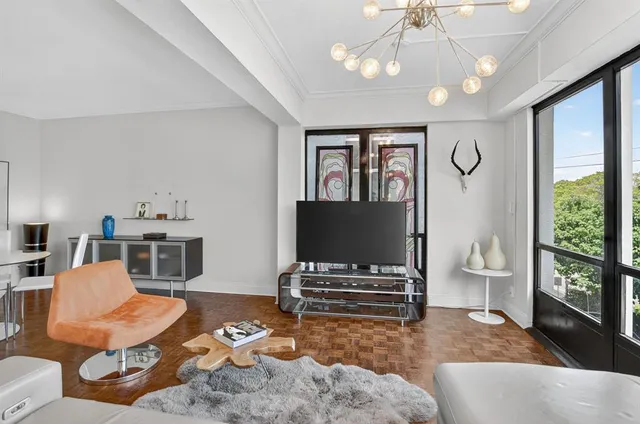 a living room with furniture a flat screen tv and a floor to ceiling window