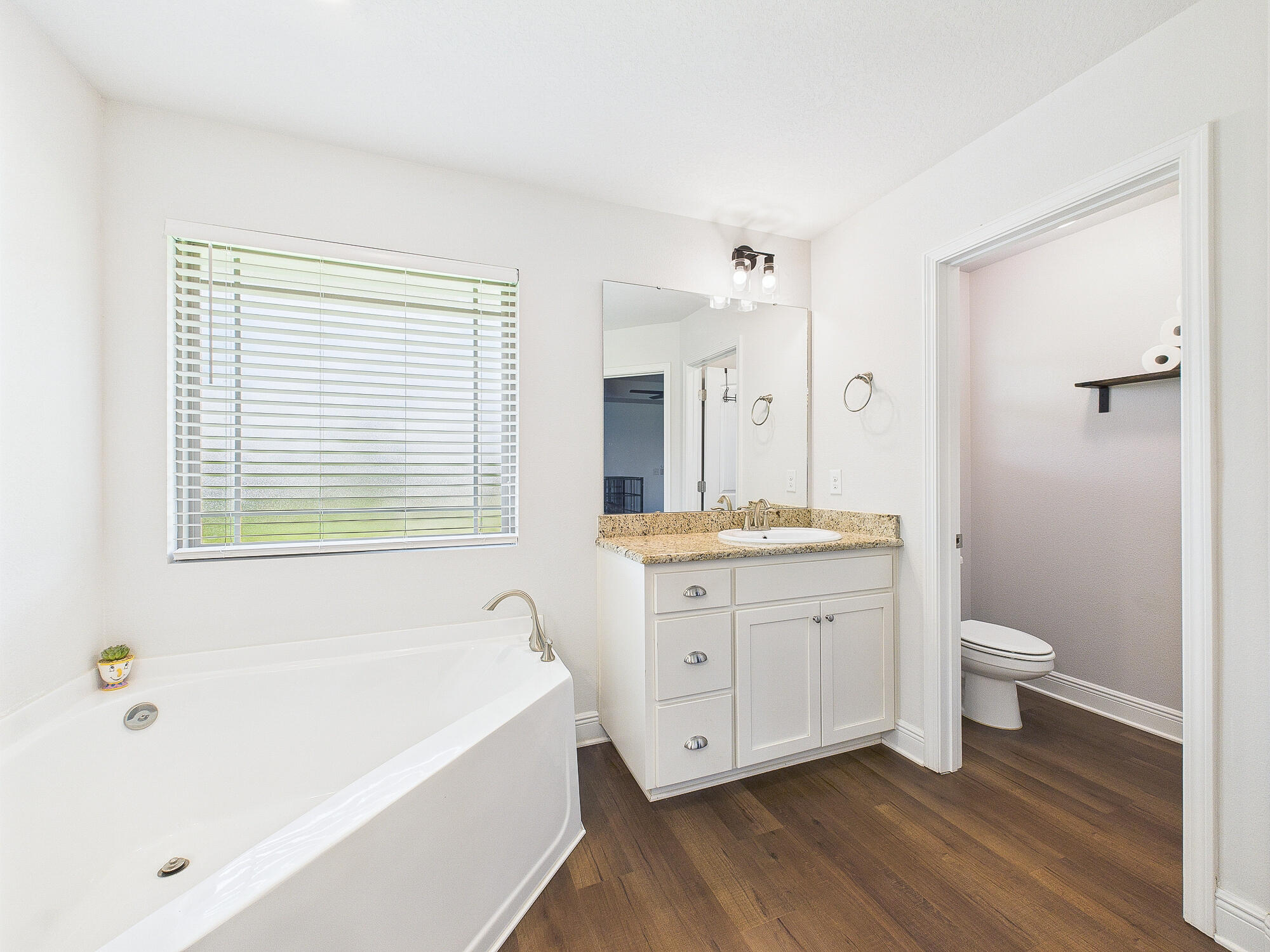 5740 Marigold Loop Crestview, FL 32539 - Photo 29 of 47 a bathroom with a granite countertop sink toilet a large mirror a bathtub and shower
