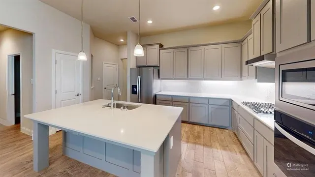 a kitchen with a sink a stove a refrigerator and a oven