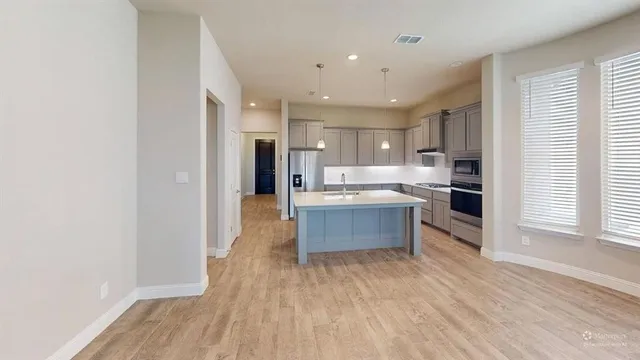 a kitchen with stainless steel appliances kitchen island wooden cabinets and granite counter tops