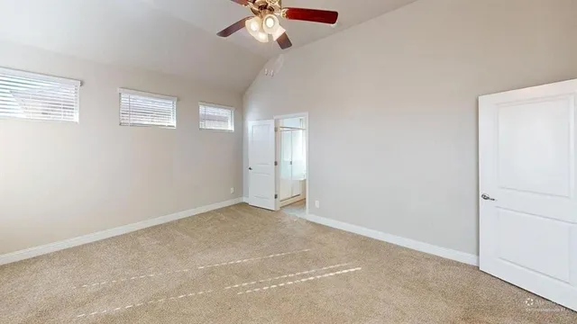 an empty room with windows and fan