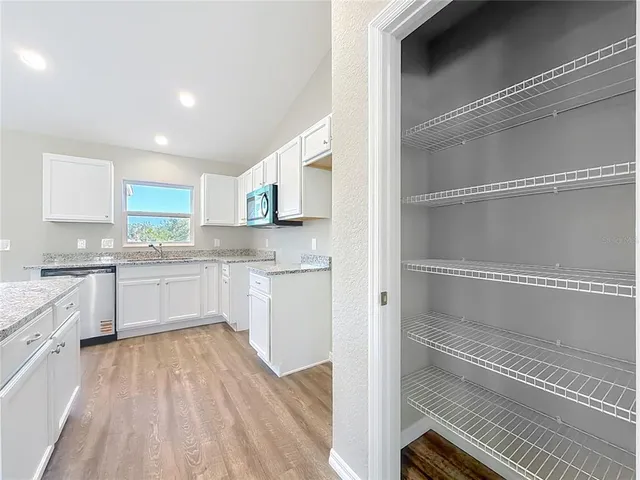 a kitchen with white cabinets and white appliances