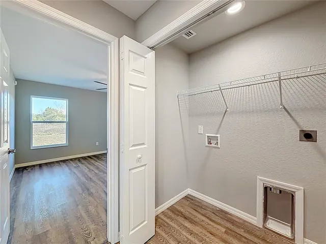 a view of a room with wooden floor and white walls