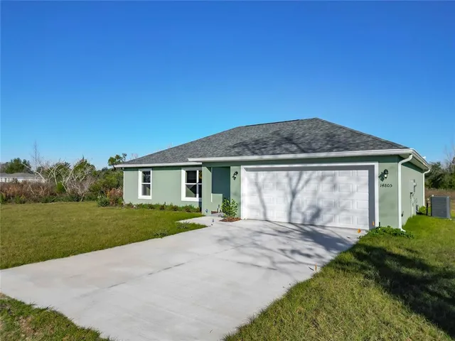 an aerial view of a house with a yard and lake view