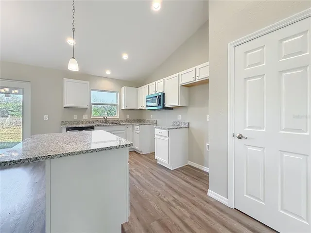 a kitchen with stainless steel appliances granite countertop a sink and a stove top oven