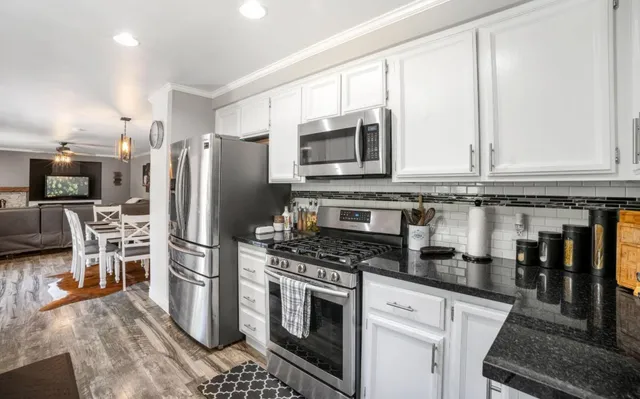 a kitchen with stainless steel appliances granite countertop a stove a refrigerator and a microwave