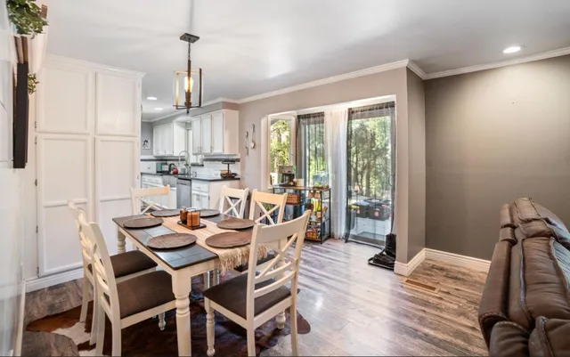 a dining room with furniture a chandelier and wooden floor