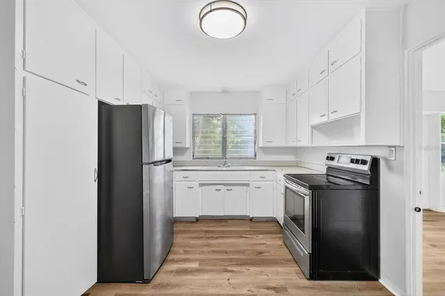 a kitchen with stainless steel appliances granite countertop a refrigerator and a stove