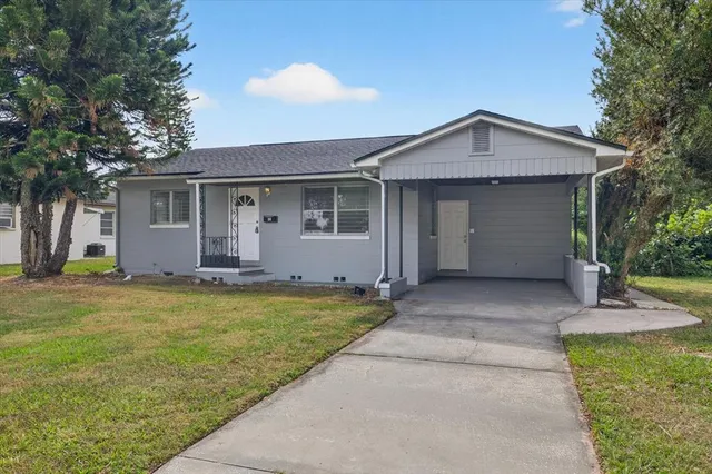 a view of a house with a yard and potted plants
