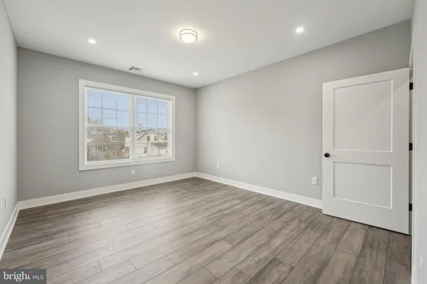 an empty room with wooden floor and window