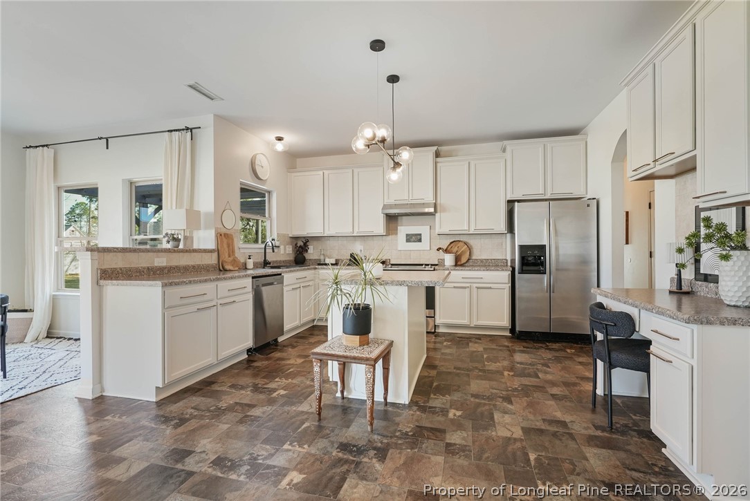 1219 Coachman Way Sanford, NC 27332 - Photo 13 of 46 a kitchen with white cabinets and stainless steel appliances