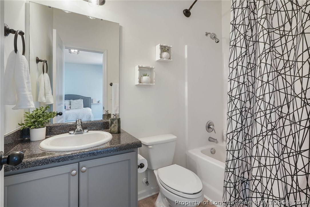 1219 Coachman Way Sanford, NC 27332 - Photo 21 of 46 a bathroom with a granite countertop toilet sink and mirror