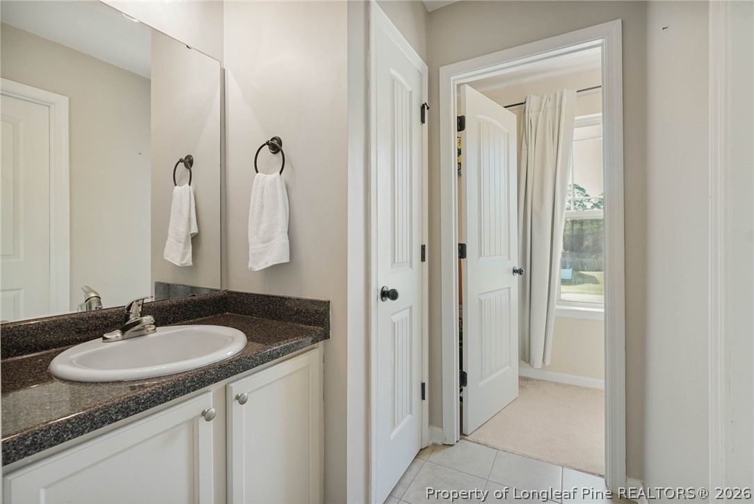 1219 Coachman Way Sanford, NC 27332 - Photo 33 of 46 a bathroom with a granite countertop sink and a mirror