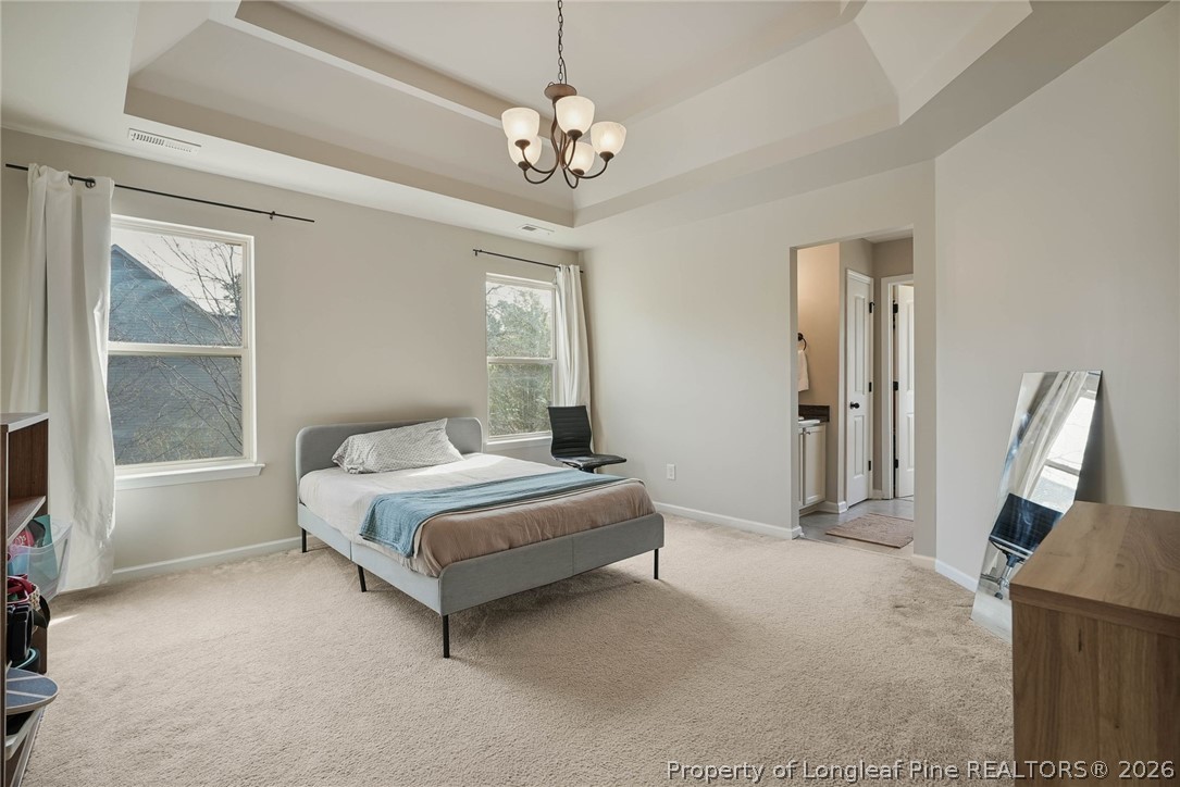1219 Coachman Way Sanford, NC 27332 - Photo 34 of 46 a spacious bedroom with a large bed and a chandelier