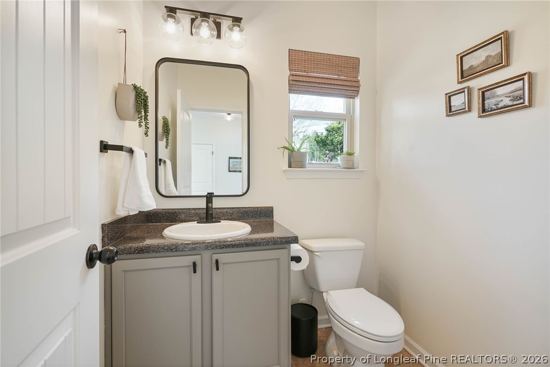 1219 Coachman Way Sanford, NC 27332 - Photo 9 of 46 a bathroom with a toilet sink and mirror