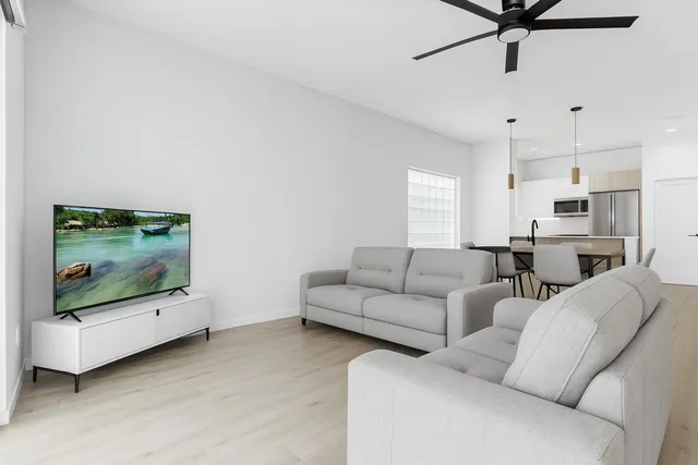 a view of a hallway with wooden floor and a living room