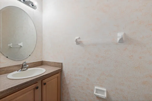 a bathroom with a granite countertop toilet a sink and shower