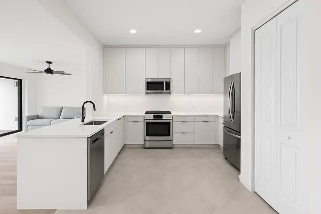 a kitchen with kitchen island granite countertop a sink cabinets and window