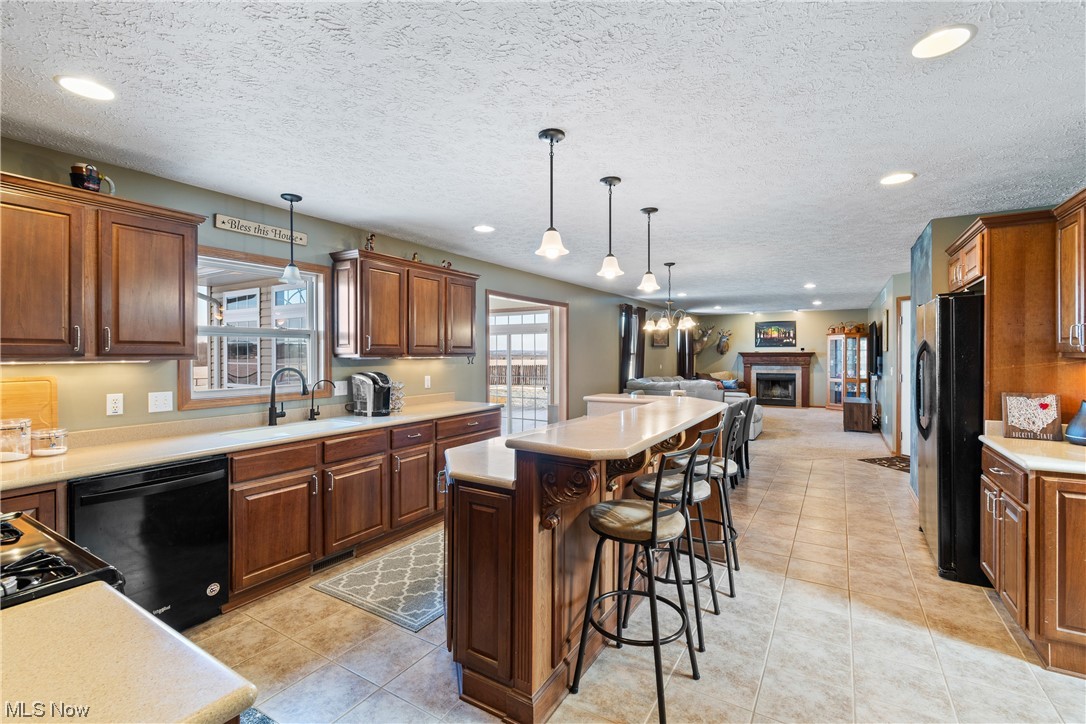 4363 Wile Road Wooster, OH 44691 - Photo 12 of 36 Kitchen with a breakfast bar, black appliances, pendant lighting, a center island, and sink